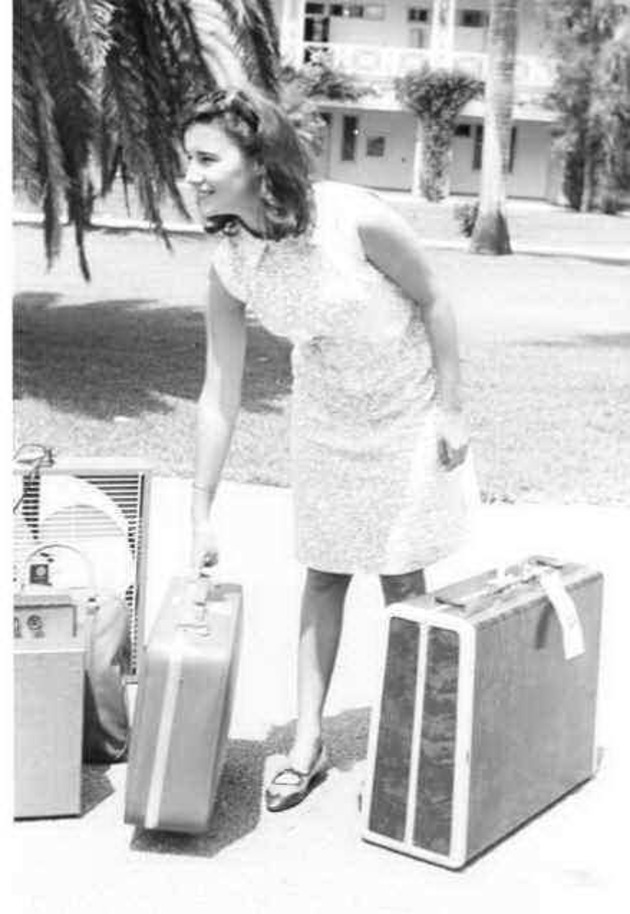 A student arrives on campus with her suitcases and an electric fan